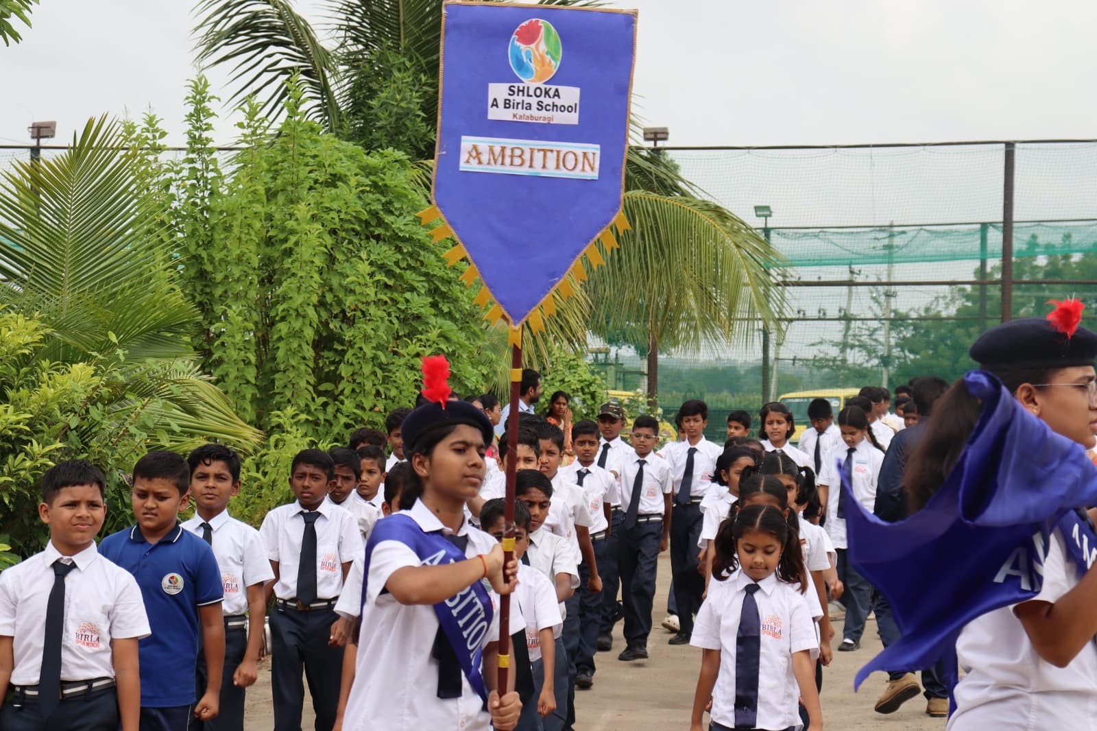 Students carrying the Ambition house banner in a school procession
